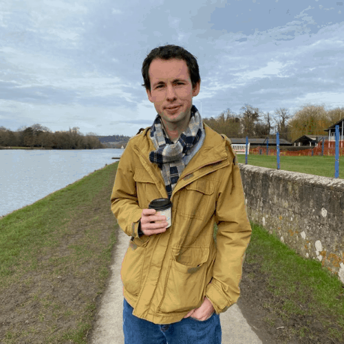 Ashden team member, Craig Burnett standing with a coffee in a yellow jacket