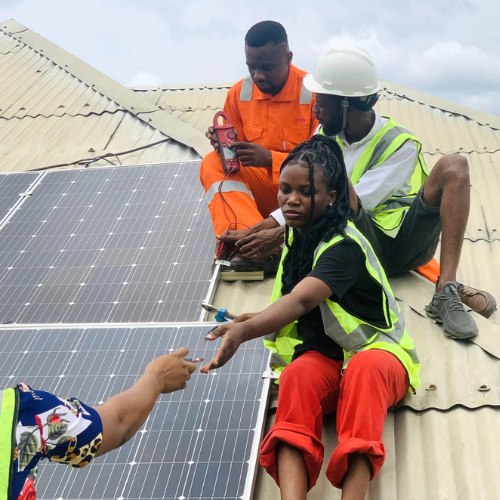 3 trainees on a roof installing solar panels