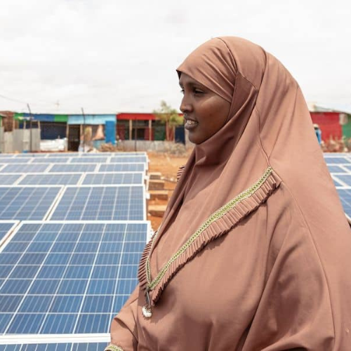 A woman standing in front of solar panels